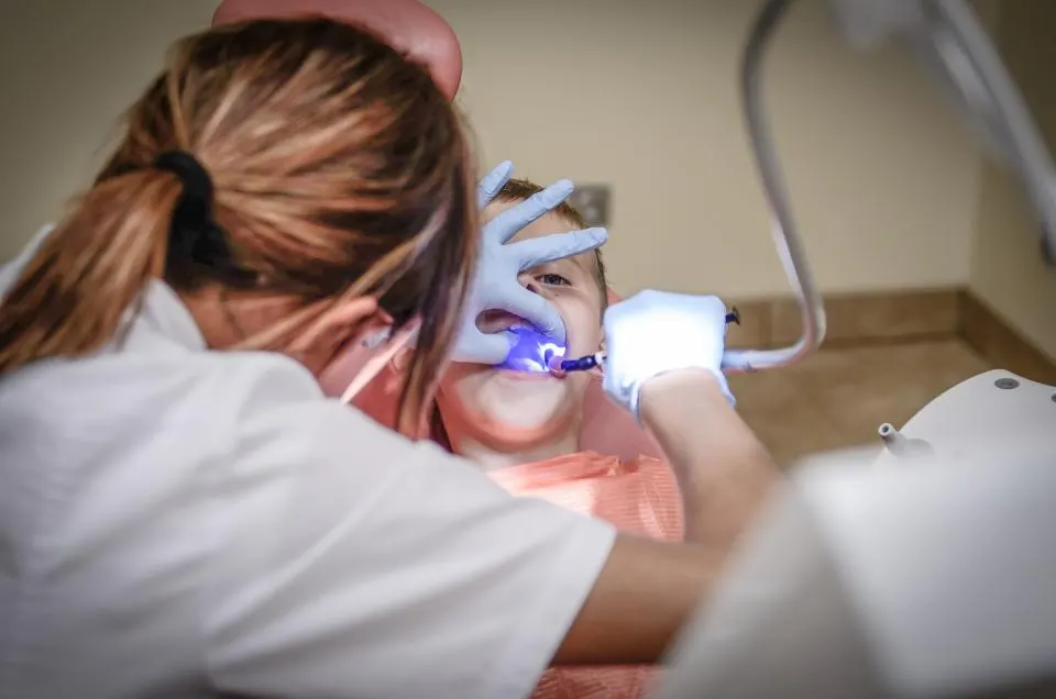 A dentist treating a young patient in a dental chair